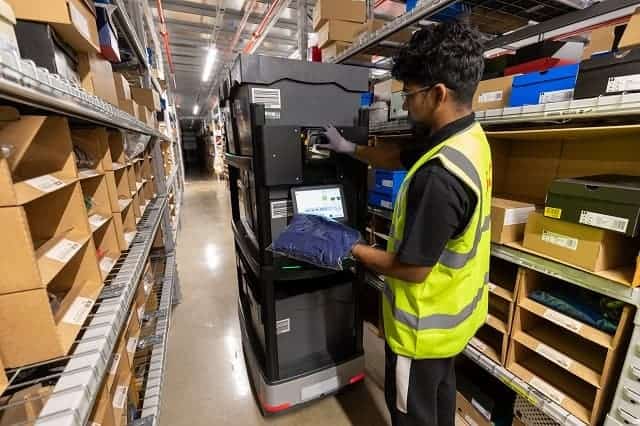 Warehouse associate working with autonomous mobile robot